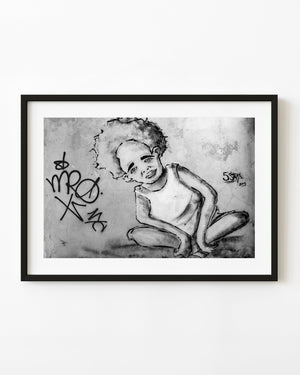 Painted boy beside graffiti on a weathered Havana wall, black and white