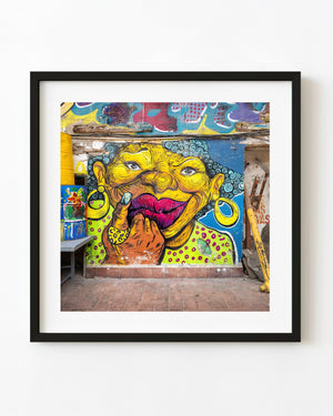 Colourful portrait mural with yellow face and pink lips in Panama City