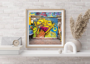 Colourful street portrait framed by blue paint and peeling plaster