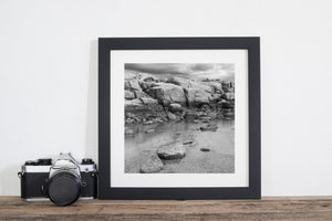 Black and white study of massive granite blocks and still water