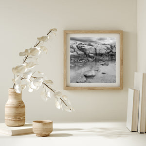 Square monochrome landscape of Peggy’s Cove rocks and shallow water