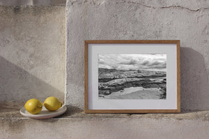 Rounded rock shelves stretching beneath a cloud-filled sky