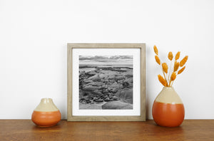 Black and white Peggy’s Cove landscape with textured stone and calm water