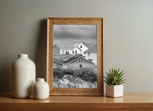Portrait view of layered village homes under an overcast coastal sky