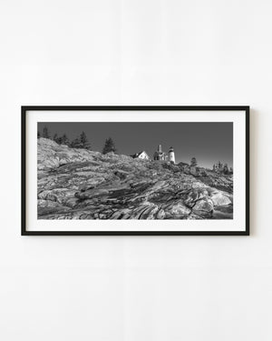 Pemaquid Point lighthouse above layered coastal rocks, black and white
