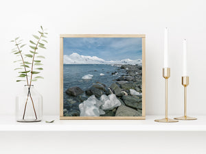 Antarctic coastal landscape with penguins beside pale ice blocks