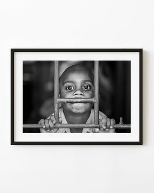 Black and white portrait of a boy at a train window in India