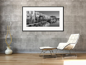 Black and white harbour scene with dock pilings, lobster traps and boats