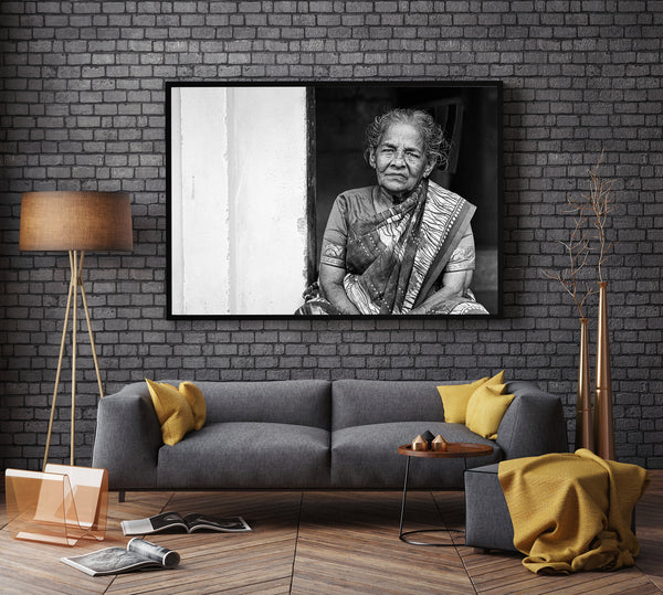 Elderly woman seated in doorway in India