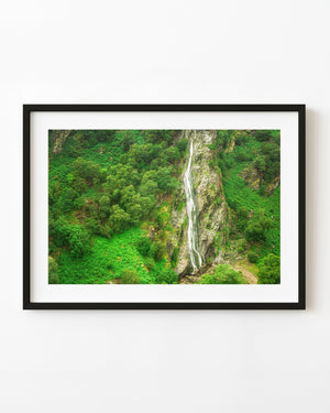Aerial view of Powerscourt Waterfall amid lush green Irish woodland