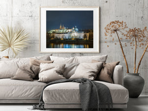 Colour photograph of Prague’s historic skyline and calm river reflections at night