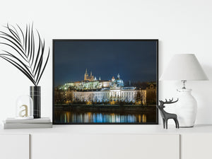 Prague Castle glowing above riverside architecture beneath the evening sky