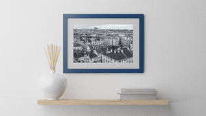 Layered city architecture with tiled roofs, ornate façades and Prague Castle