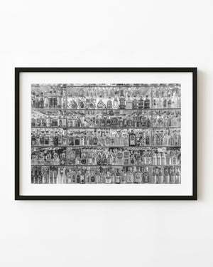 Rows of liquor bottles in a Prague shop display photographed in black and white