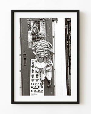 Marionette puppets hanging outside a Prague workshop in black and white