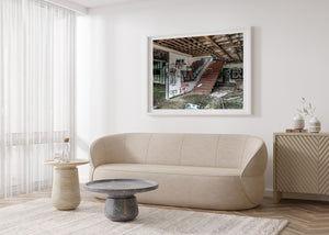 Abandoned motel reception area with graffiti, red stairs and scattered debris