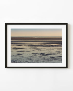 Layered Alaska tidal flats beneath a soft pastel sunset sky