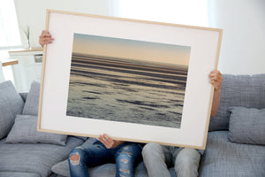 Zonsondergang die over kalme oceaan nadenkt