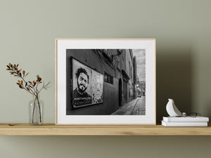 Monochrome photograph of Dublin at dawn with posters and receding cobblestones