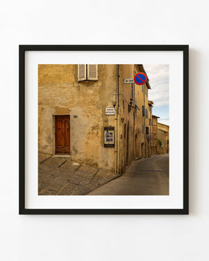Weathered Tuscan village street corner with shuttered window and old plaster walls