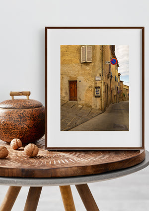 Shuttered window above a wooden door on a weathered Tuscan street corner