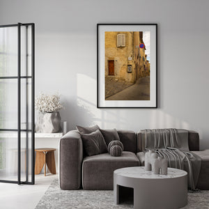 Quiet hillside street in Tuscany with shuttered window and textured walls