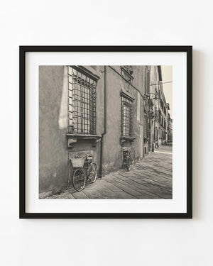 Bicycles leaning beneath barred windows on a quiet Tuscan street