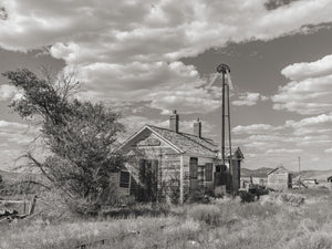 Old windmill with two blades left in ghost town
