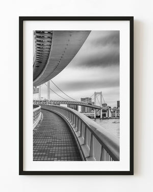 Monochrome pedestrian walkway beneath Rainbow Bridge in Tokyo