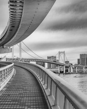 Curved bridge walkway overlooking Tokyo Bay cityscape
