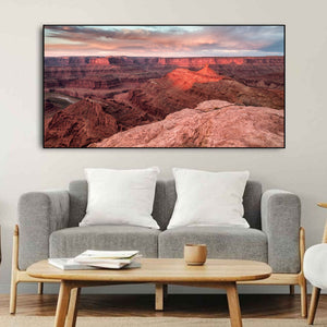 Pink cloud bands stretching over broad red desert cliffs