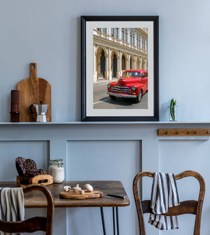 Colourful Havana street photograph with a red car and colonial architecture