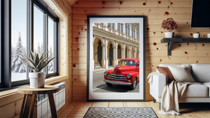 Red classic taxi driving past an elegant arched building in Cuba