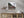Small Norwegian boathouse at the foot of a dark mountain slope