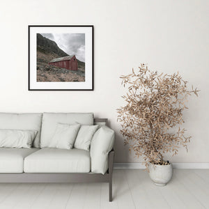 Overcast sky above an isolated red boathouse in the Lofoten landscape