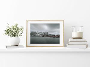 Horizontal photograph of Norwegian fishing cabins beside calm water