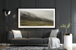 Fog drifting across rugged mountain above Iceland countryside farm