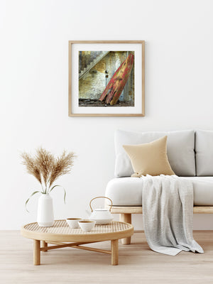Artistic shot of a lone red rowboat against a rugged wall