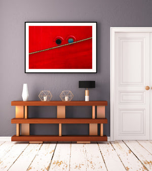 Colour nautical photograph of two portholes against a red hull
