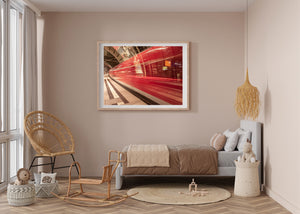 Long exposure of a red train beneath the station’s arched steel roof