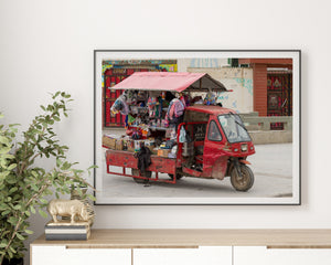 Colour street photograph of a vendor truck carrying toys and household goods