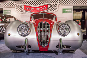 Classic Jaguar with rounded silver fenders and a red hood
