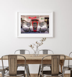 Vintage Jaguar displayed beneath a Hot Rod sign