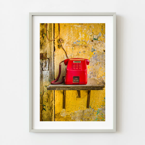 Red payphone on broken shelf