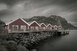 Traditional rorbu cabins beneath a rocky Lofoten ridge