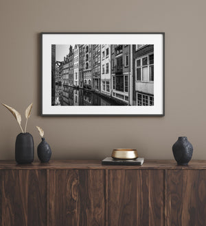 Tall Amsterdam homes along canal with mirrored detail