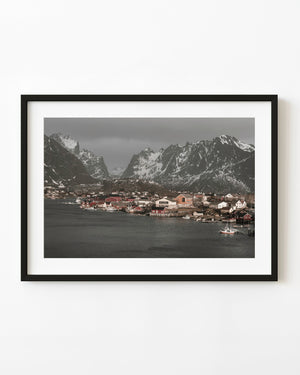Reine waterfront houses and fishing boats beneath snowy Norwegian mountains
