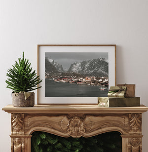 Snow-covered mountain slopes rising behind Reine’s fishing harbour