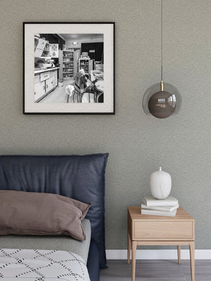 Square monochrome photograph of a densely furnished vintage kitchen