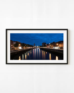 River Liffey at dawn with city lights reflected beneath a deep blue Dublin sky